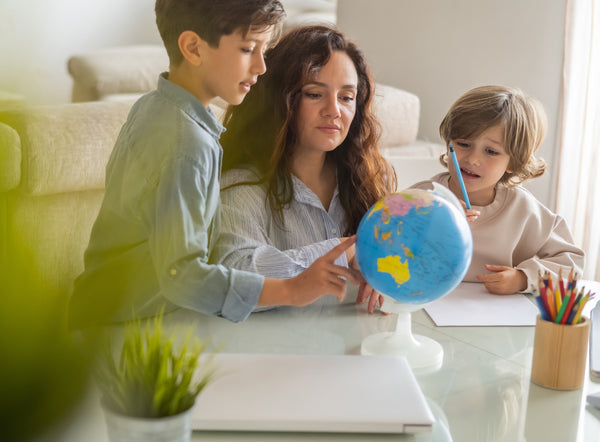 Mother and two children looking at a globe together