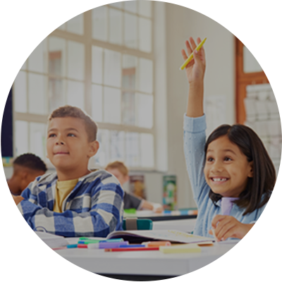 Children in a classroom with one raising their hand