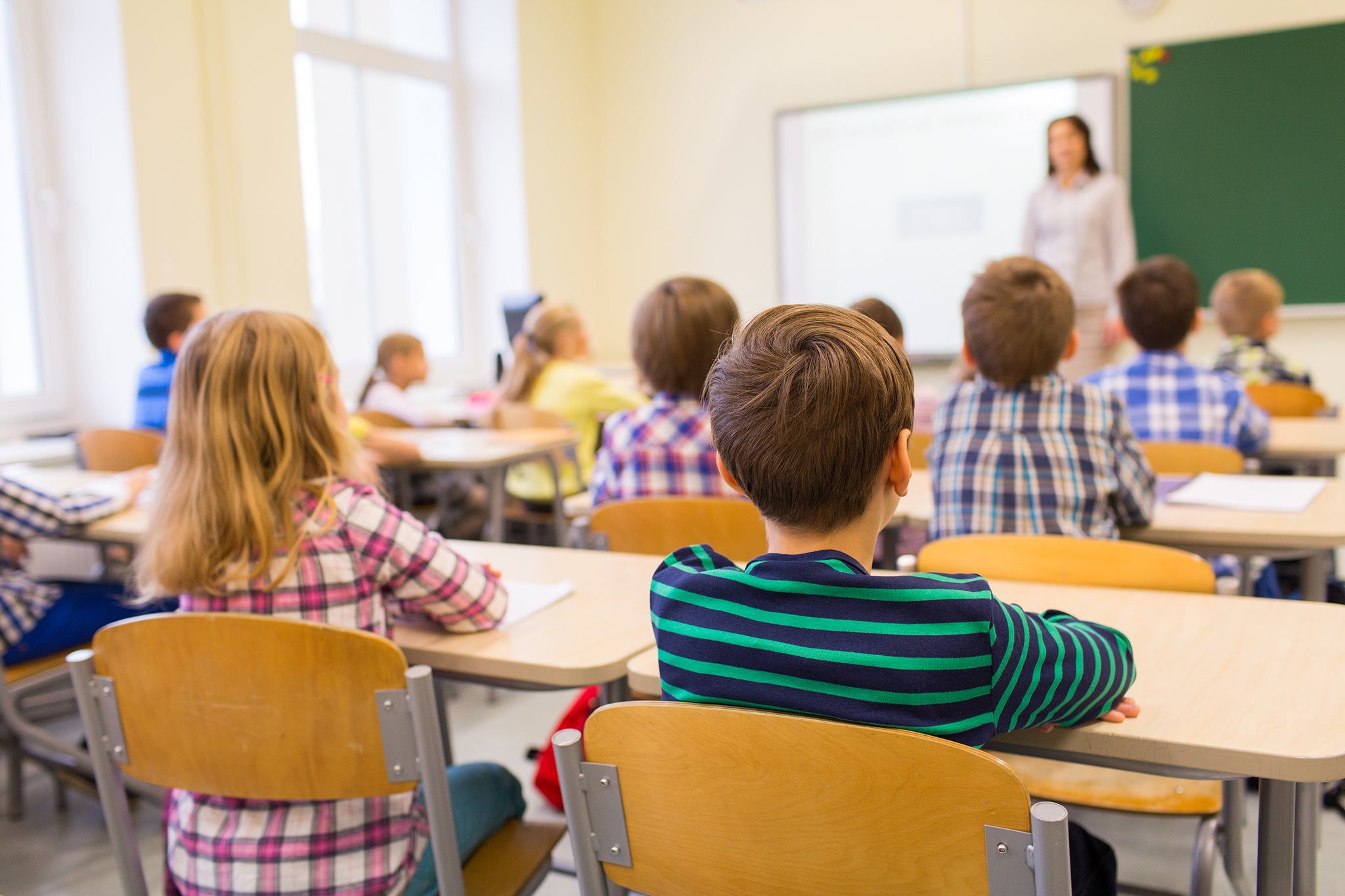 Classroom full of seated children looking at their teacher