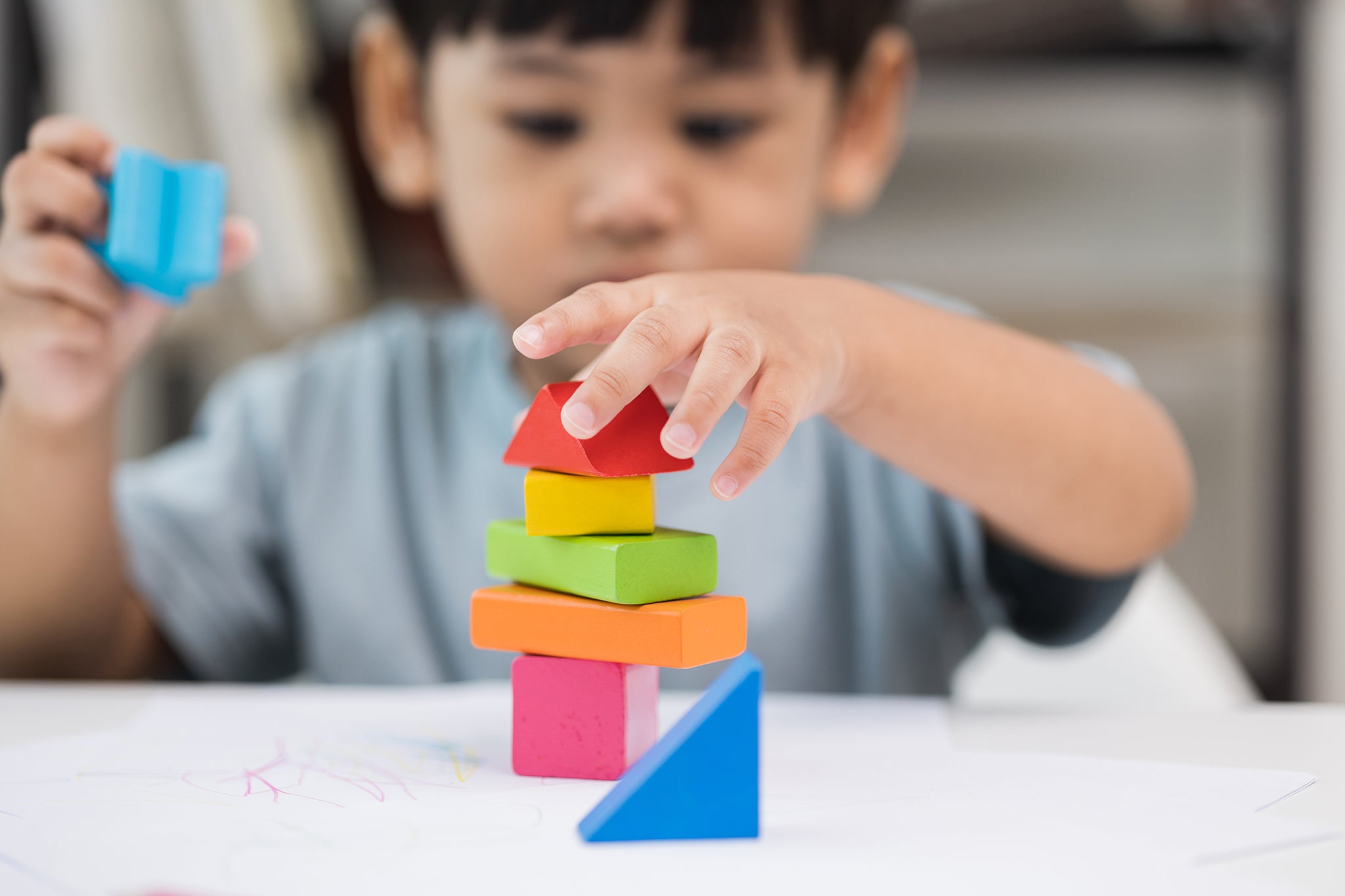 Young boy stacking colorful blocks