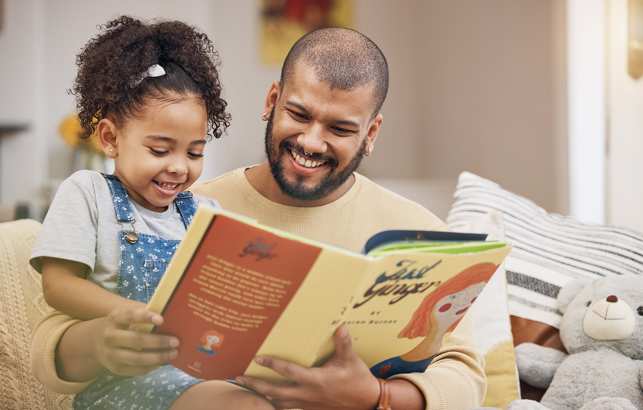 Father and daughter reading a book together and smiling