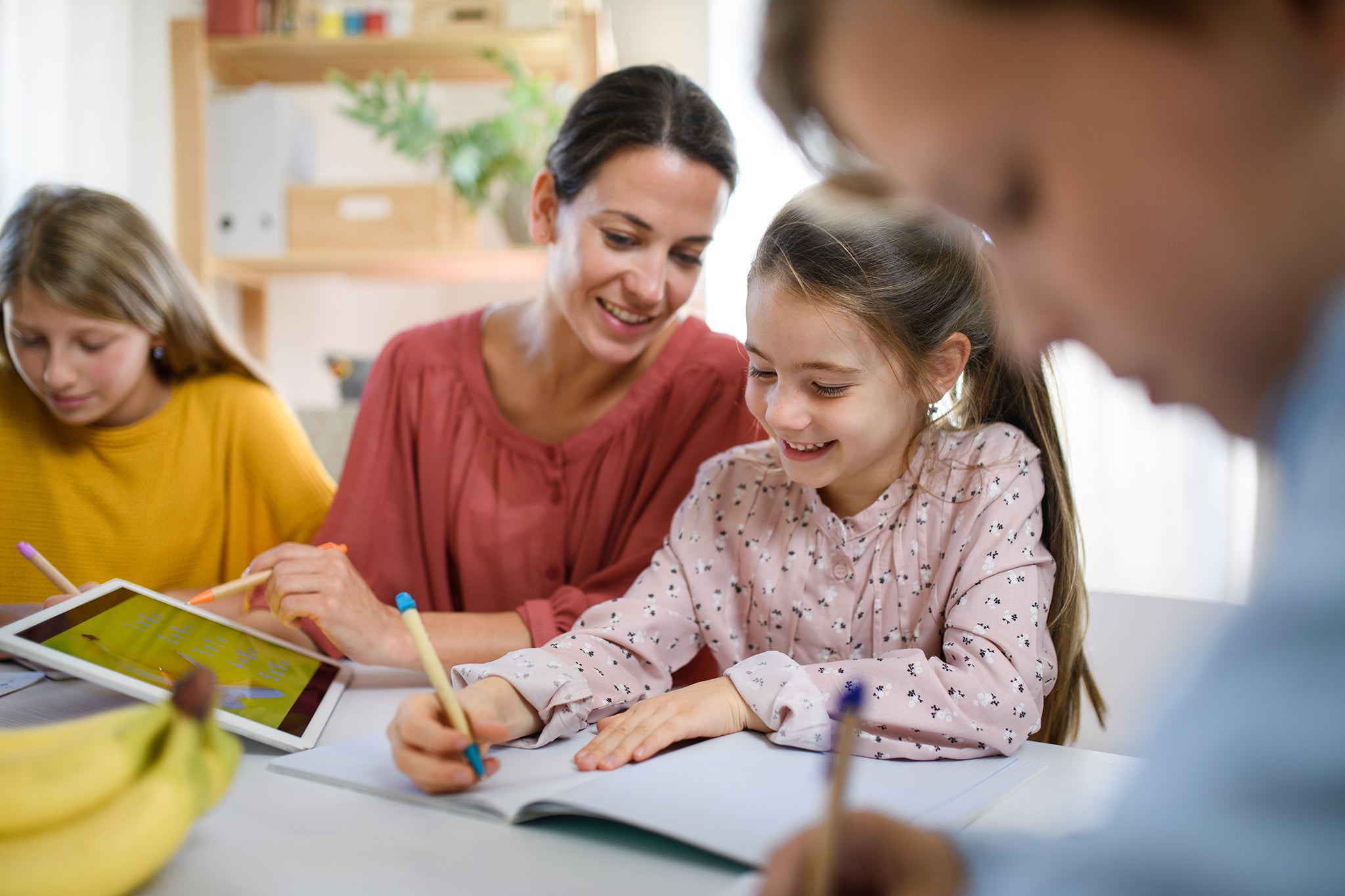Mother and three kids doing homework together