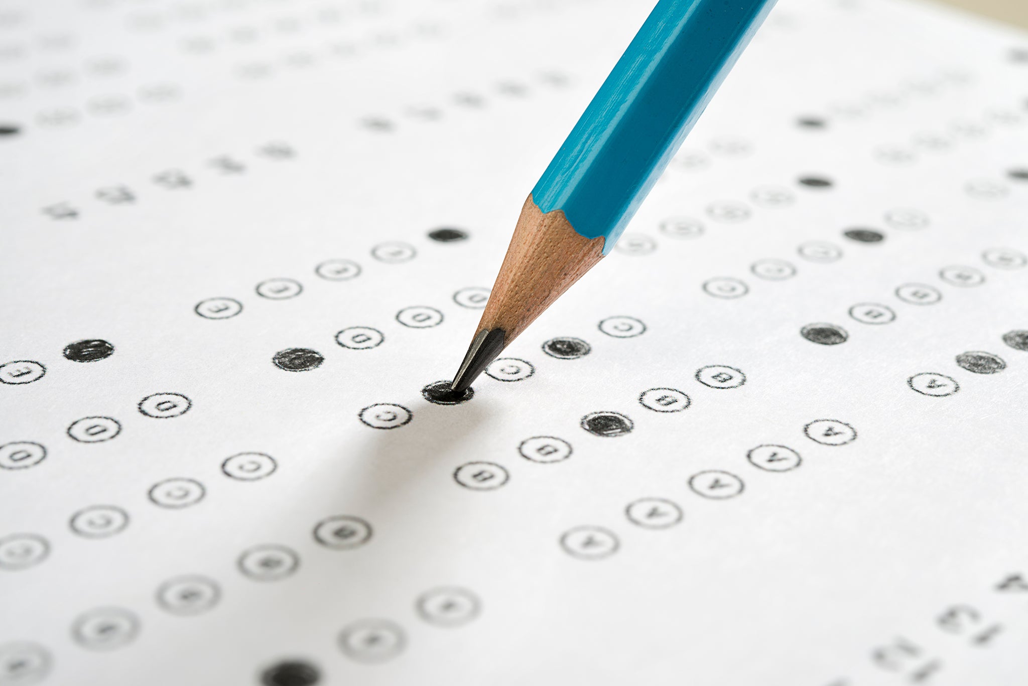 Close-up of a blue pencil filling in a circle on a standardized test
